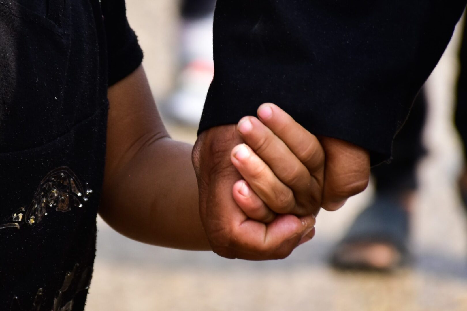 A close up of two people holding hands